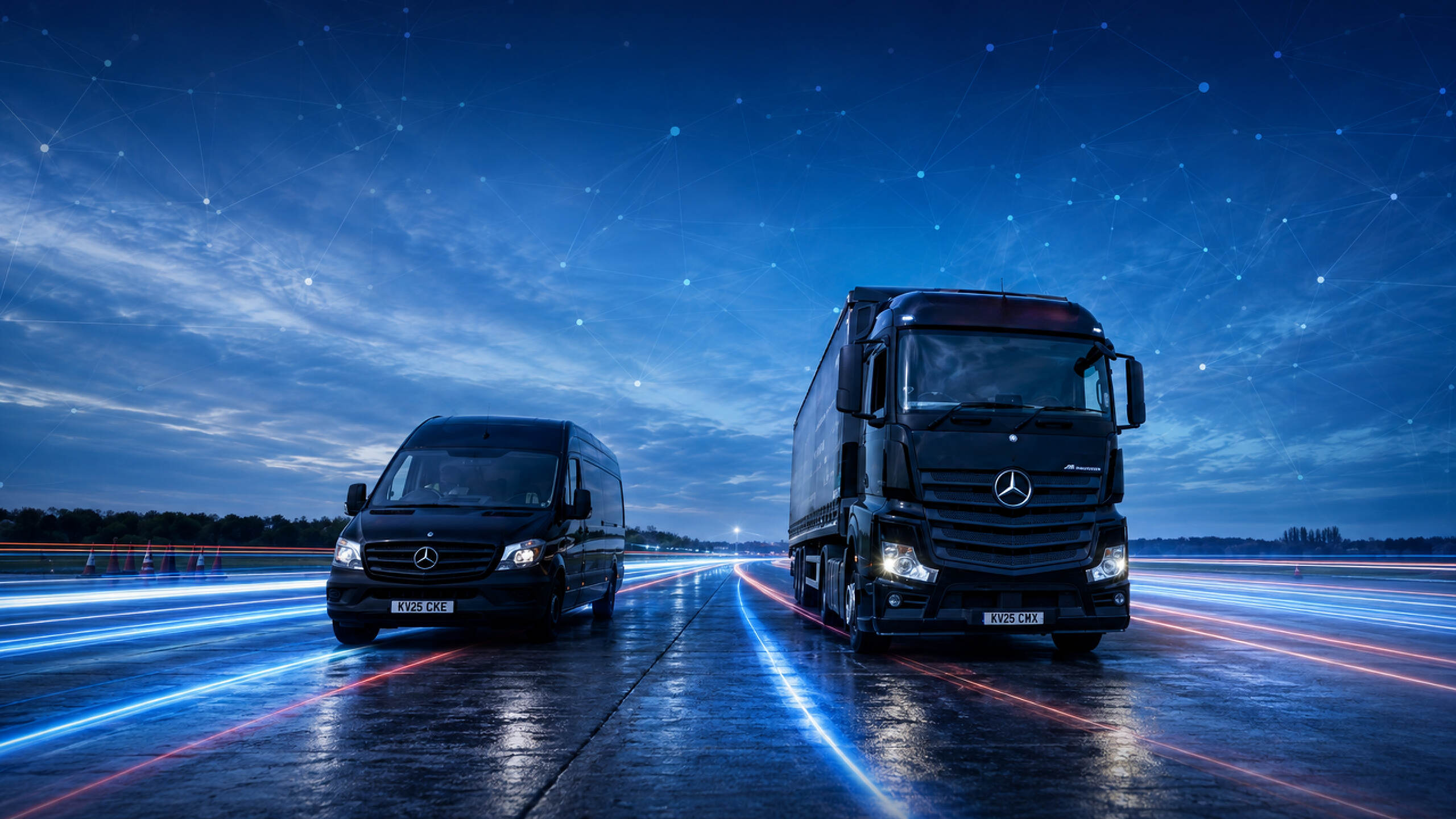 An AMCO truck and van on a wet road at dusk, both carrying the AMCO mark.